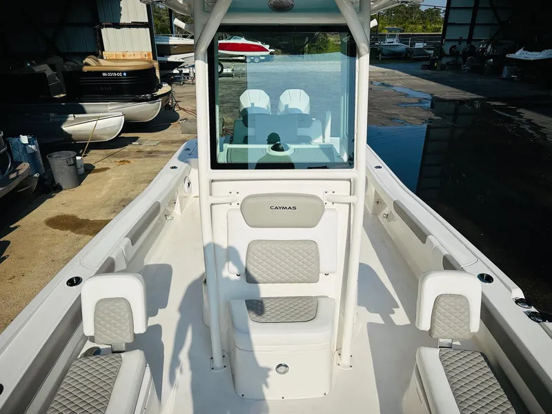 Slide: The Image of 2024 Caymas 281 HB boat interior with seating and console, docked in a marina. - 31