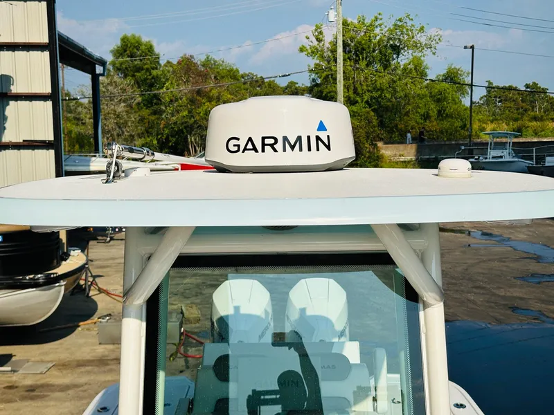 Slide: The Image of 2024 Caymas 281 HB boat with Garmin radar on top, docked outdoors. - 32