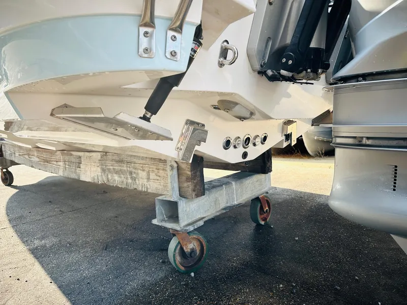 Slide: The Image of 2024 Caymas 281 HB boat on a wheeled stand, showcasing the hull and motor area. - 6