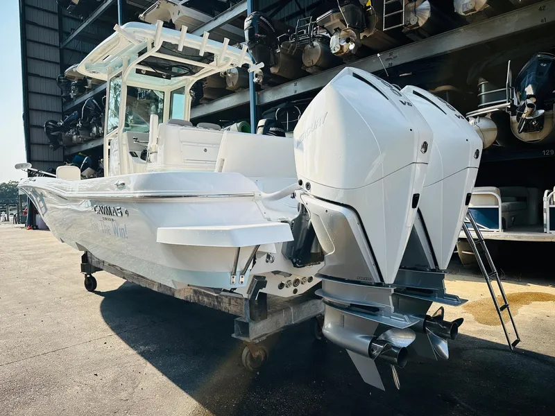 Slide: The Image of 2024 Caymas 281 HB boat with dual outboard engines, docked in a marina. - 7