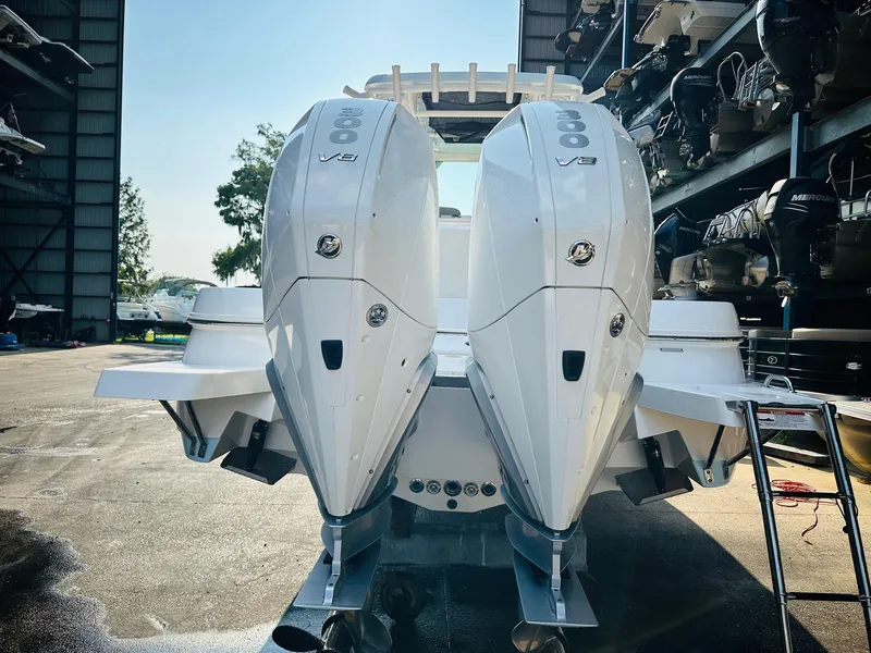 Slide: The Image of 2024 Caymas 281 HB boat with dual outboard engines in a marina setting. - 8