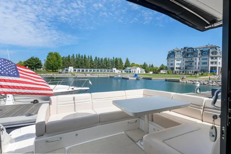 Slide: The Image of 2015 Sea Ray 510 Sundancer yacht with seating area, docked in a scenic marina. - 10