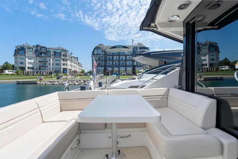 Slide: The Image of 2015 Sea Ray 510 Sundancer yacht with luxurious seating, docked near elegant waterfront buildings. - 9