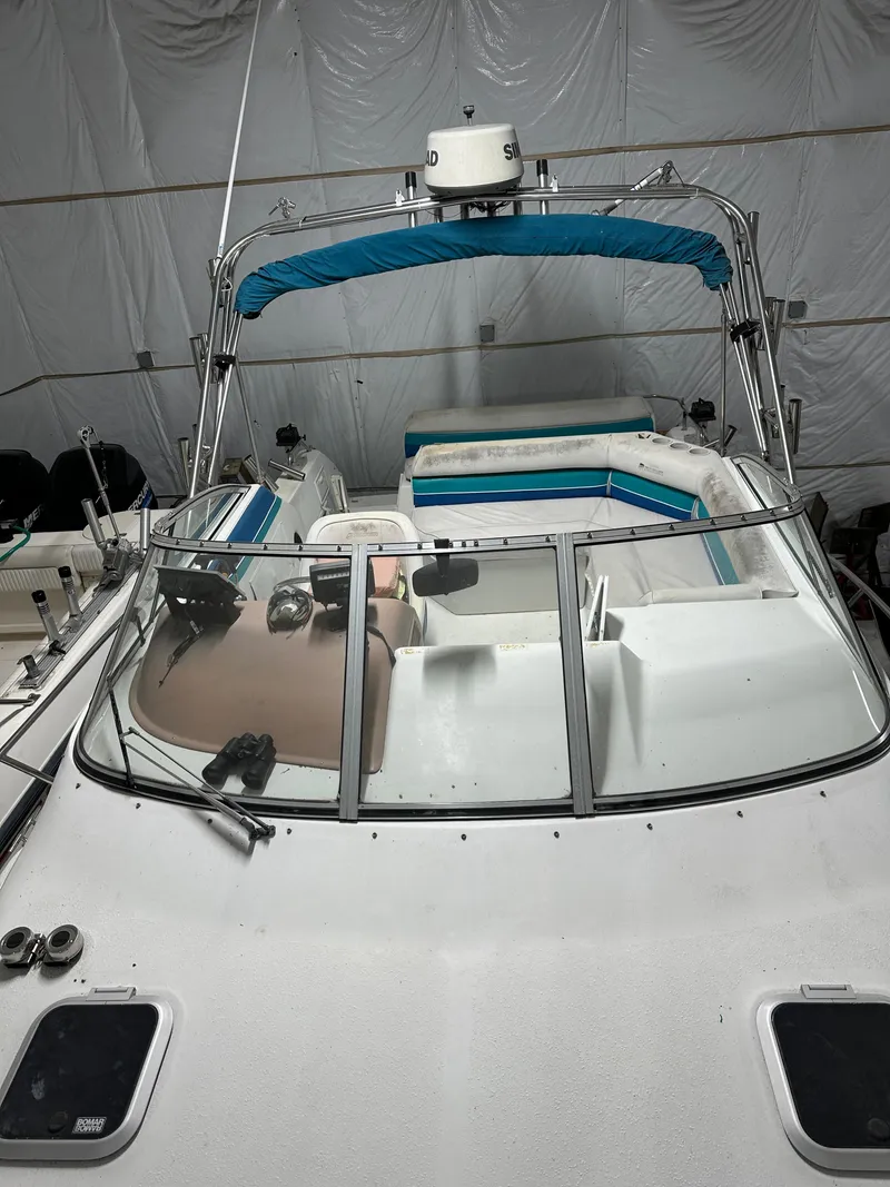 Slide: The Image of 1993 Rinker 280 Fiesta Vee boat with blue canopy in storage. - 13