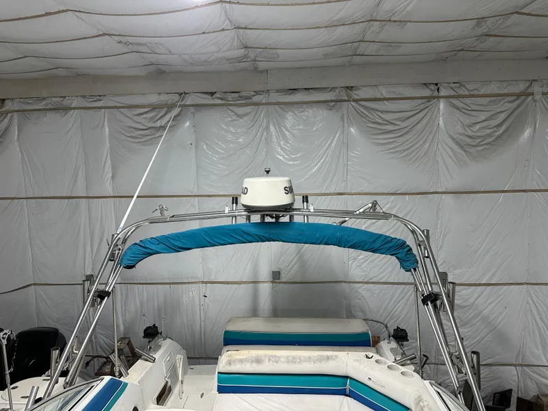 Slide: The Image of 1993 Rinker 280 Fiesta Vee boat in storage, featuring blue and white seating. - 16