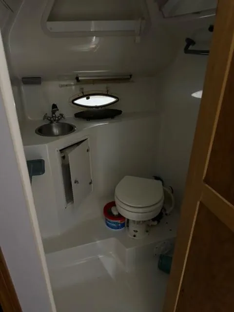 Slide: The Image of 1993 Rinker 280 Fiesta Vee boat bathroom with sink, toilet, and porthole window. - 18