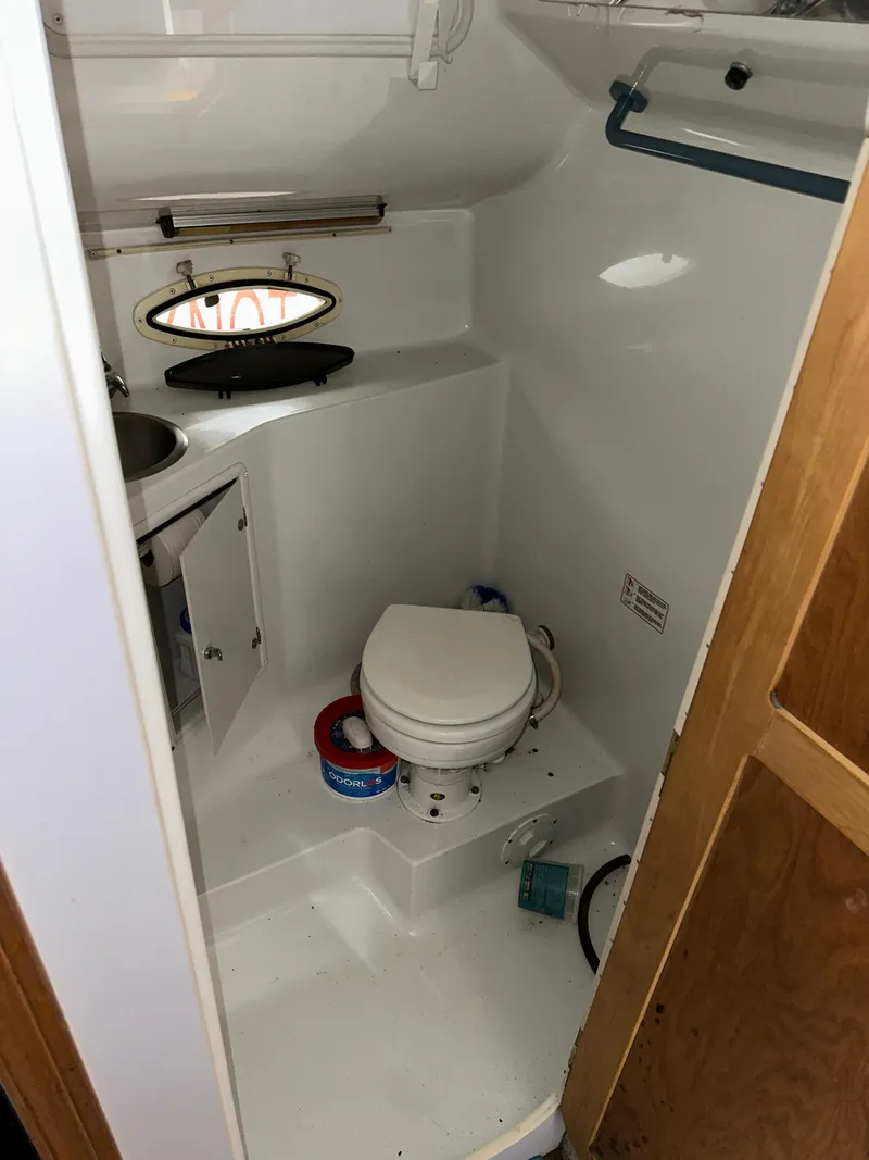Slide: The Image of 1993 Rinker 280 Fiesta Vee boat bathroom with toilet, sink, and storage cabinet. - 19