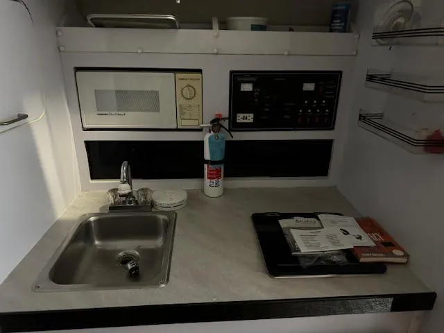 Slide: The Image of 1993 Rinker 280 Fiesta Vee boat kitchenette with sink, microwave, and control panel. - 21