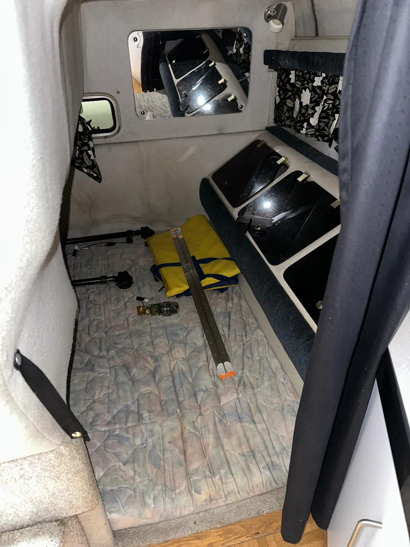 Slide: The Image of 1993 Rinker 280 Fiesta Vee cabin interior with bed and storage compartments. - 24