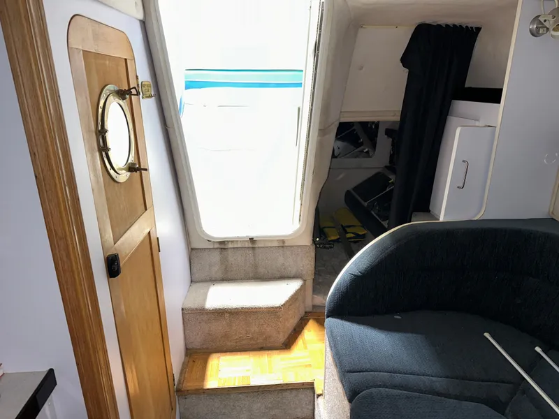 Slide: The Image of Interior of 1993 Rinker 280 Fiesta Vee boat with steps, porthole door, and seating area. - 28
