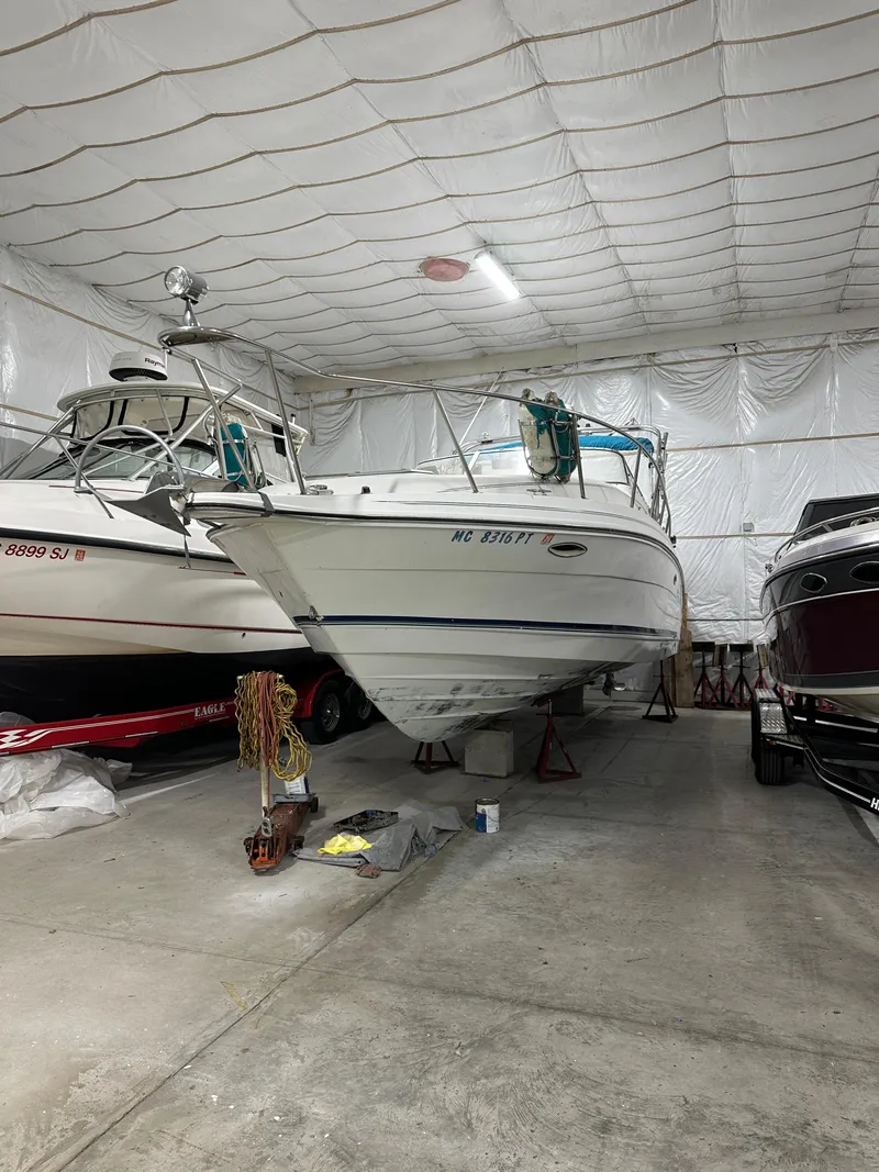 Slide: The Image of 1993 Rinker 280 Fiesta Vee boat stored indoors, surrounded by other boats. - 3