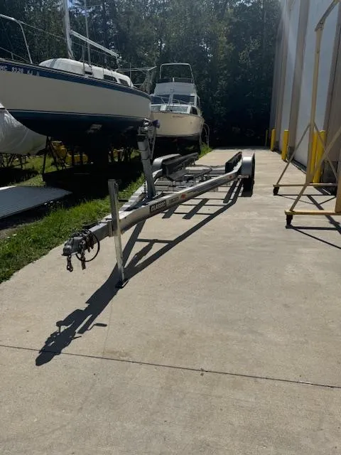 Slide: The Image of Boat trailer on concrete near Rinker 280 Fiesta Vee, 1993 model, in outdoor storage area. - 32