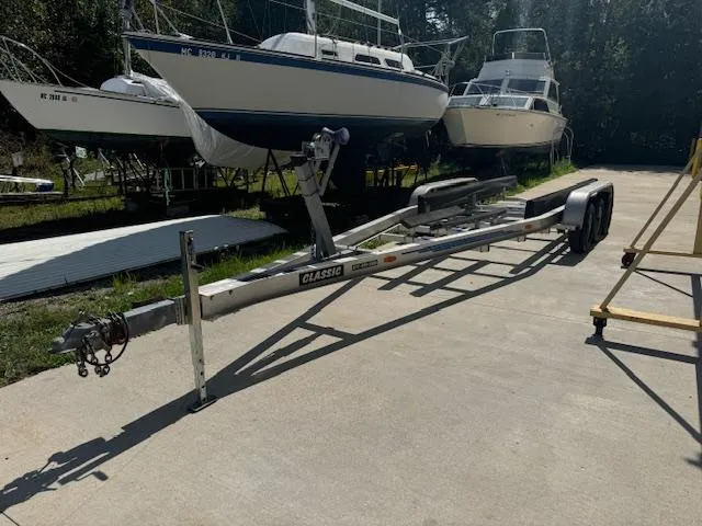 Slide: The Image of Boat trailer near Rinker 280 Fiesta Vee 1993, parked on concrete with other boats. - 33