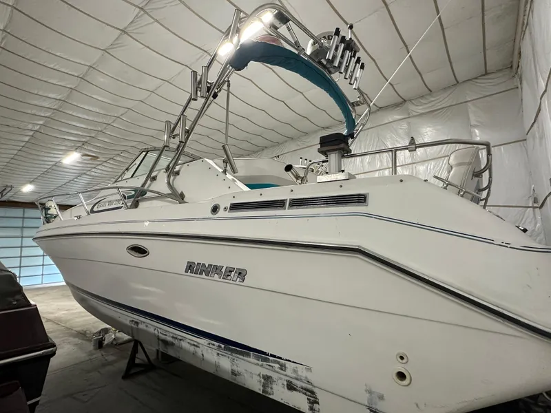 Slide: The Image of 1993 Rinker 280 Fiesta Vee boat in indoor storage, white hull, blue accents. - 5