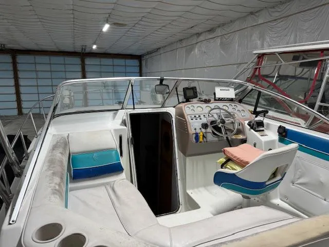 Slide: The Image of 1993 Rinker 280 Fiesta Vee boat interior with steering wheel and seating in a storage facility. - 9