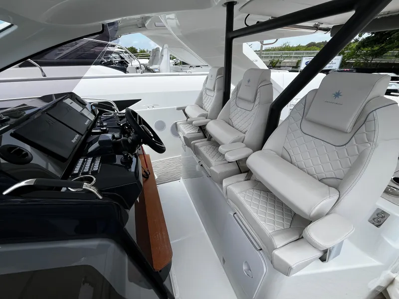 Slide: The Image of 2024 Jeanneau DB37 cockpit with luxurious white seating and modern control panel. - 16