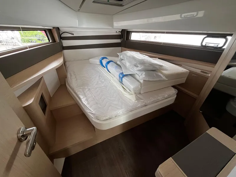 Slide: The Image of 2024 Jeanneau DB37 cabin interior with bed, modern design, and natural light. - 21
