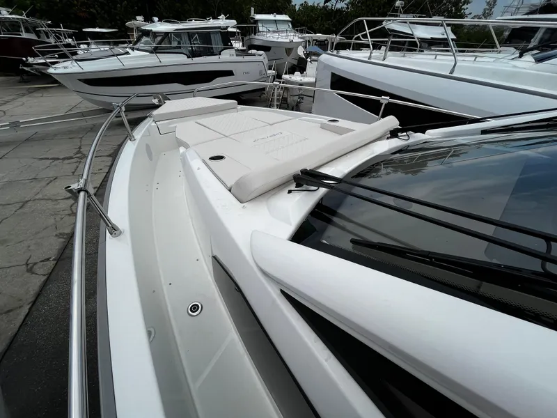 Slide: The Image of 2024 Jeanneau DB37 boat with sleek design and spacious deck, docked among other boats. - 29