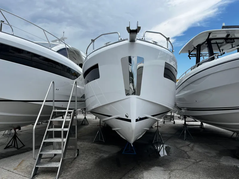 Slide: The Image of 2024 Jeanneau DB37 yacht displayed between two boats under a cloudy sky. - 3