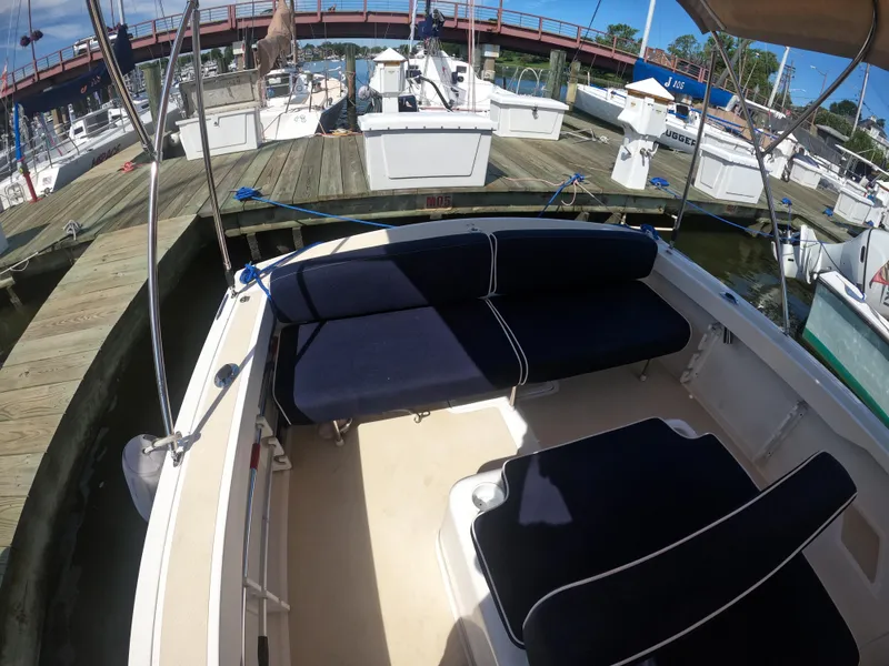 Slide: The Image of 2005 Hunt Yachts Surfhunter 25 at dock, featuring navy blue seating. - 13