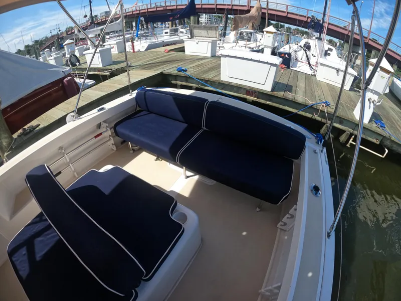 Slide: The Image of 2005 Hunt Yachts Surfhunter 25 with navy seating at a marina. - 14