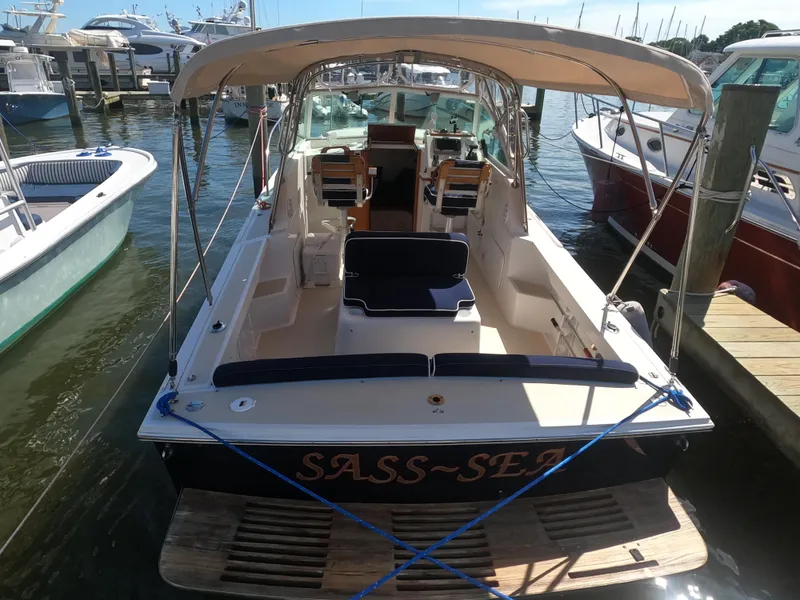 Slide: The Image of 2005 Hunt Yachts Surfhunter 25 docked, featuring a canopy and spacious seating. - 17