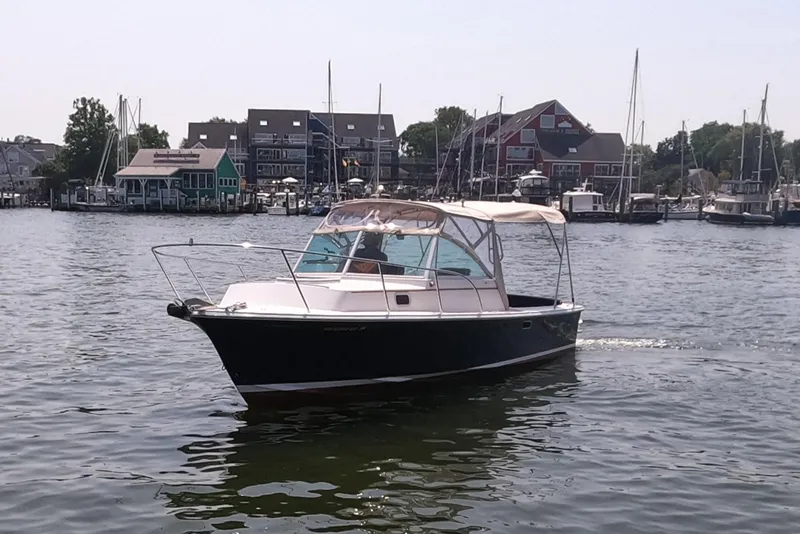 Slide: The Image of 2005 Hunt Yachts Surfhunter 25 cruising in a marina with sailboats and buildings in the background. - 2