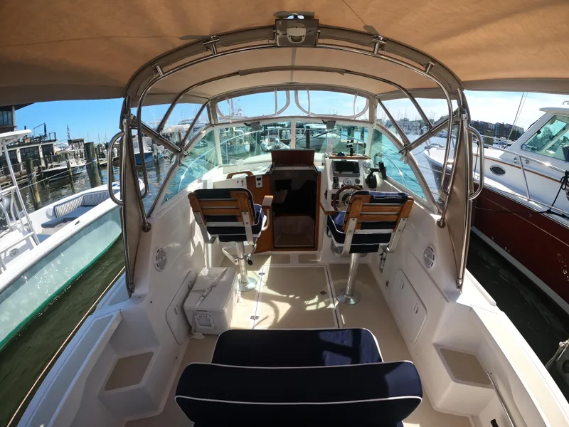 Slide: The Image of 2005 Hunt Yachts Surfhunter 25 interior with helm and seating, docked at marina. - 7