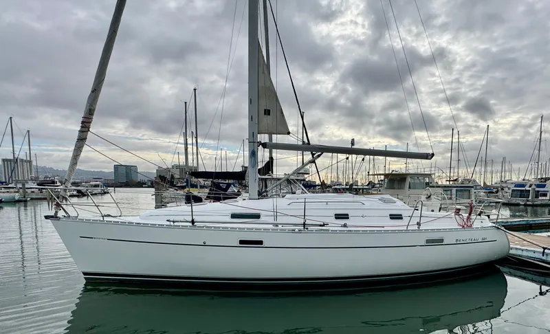 Slide: The Image of 2001 Beneteau Oceanis 331 sailboat docked in a marina under cloudy skies. - 0