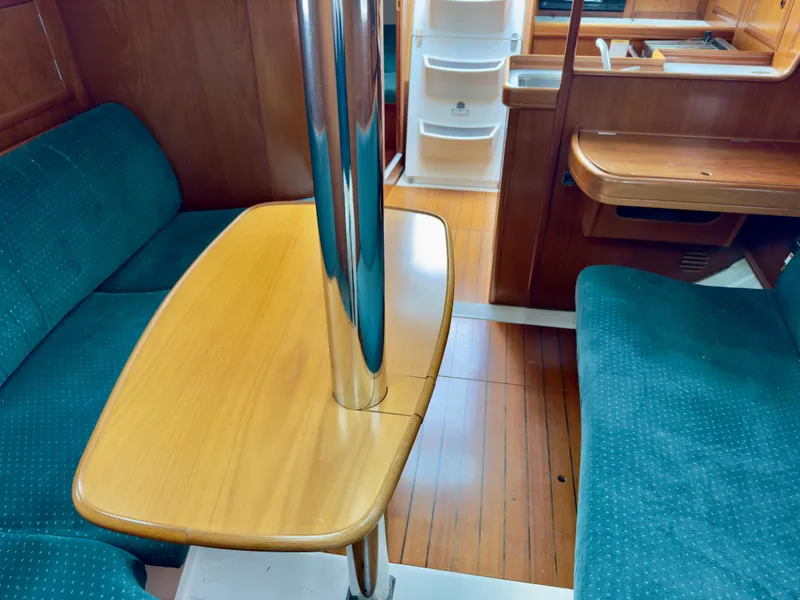 Slide: The Image of Interior of 2001 Beneteau Oceanis 331 sailboat with wooden table and blue seating. - 17