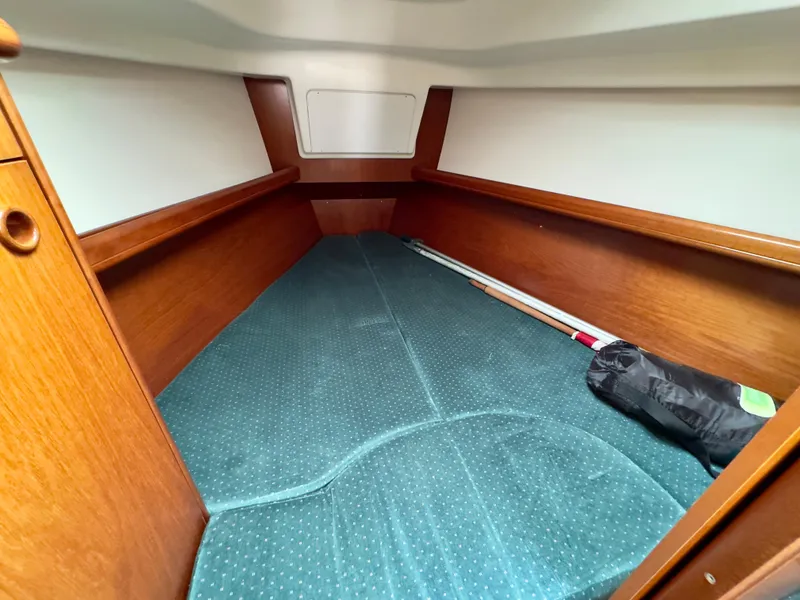 Slide: The Image of Interior cabin of 2001 Beneteau Oceanis 331 sailboat with wooden trim and teal upholstery. - 19