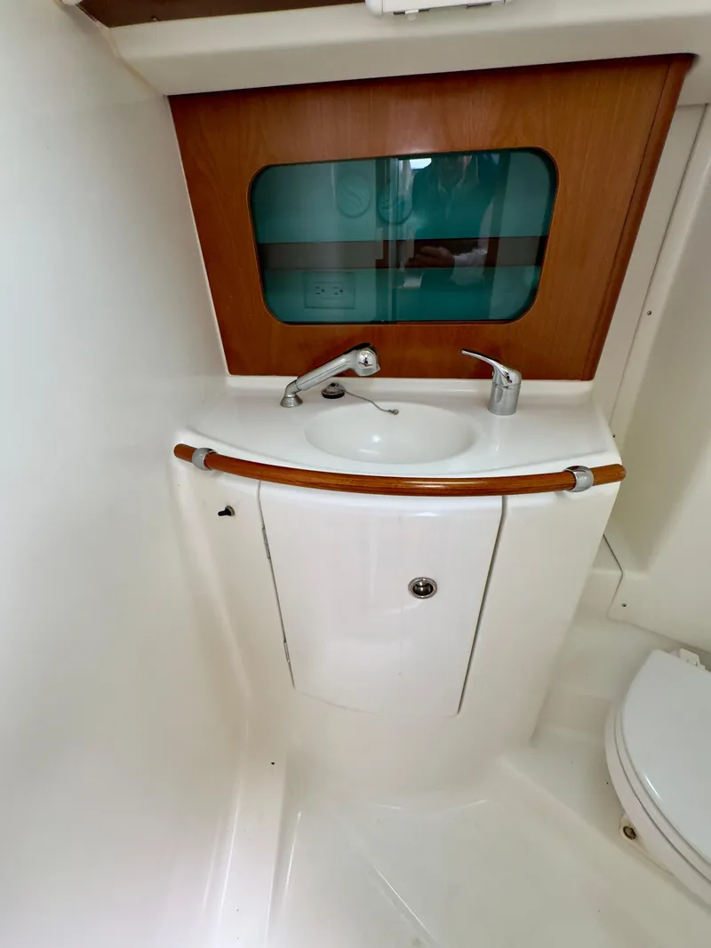 Slide: The Image of 2001 Beneteau Oceanis 331 bathroom with sink and toilet, featuring wood accents. - 21