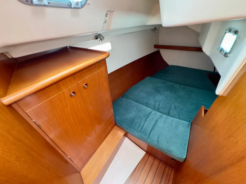 Slide: The Image of 2001 Beneteau Oceanis 331 cabin interior with wooden cabinetry and cozy sleeping area. - 23
