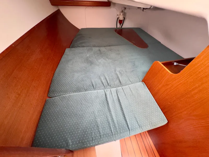 Slide: The Image of 2001 Beneteau Oceanis 331 cabin interior with green cushions and wooden paneling. - 24