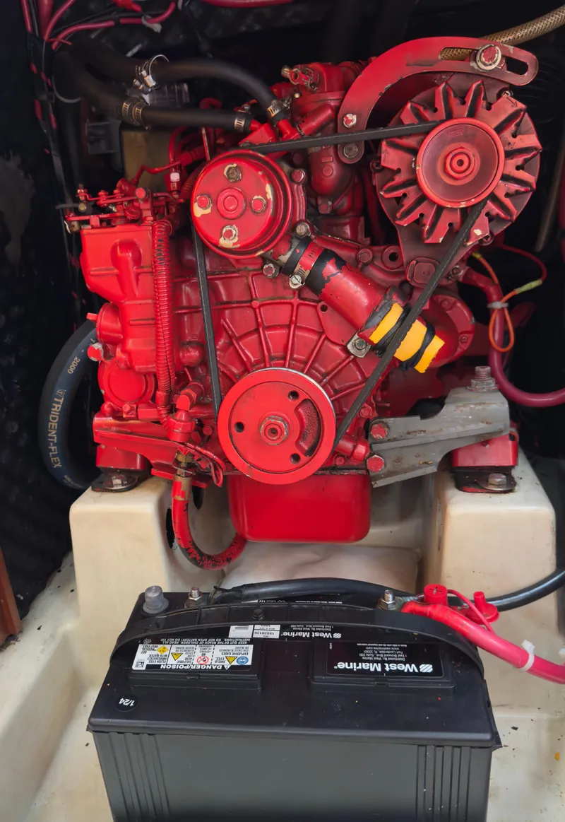 Slide: The Image of Red engine of a 2001 Beneteau Oceanis 331 sailboat with a battery in the foreground. - 26