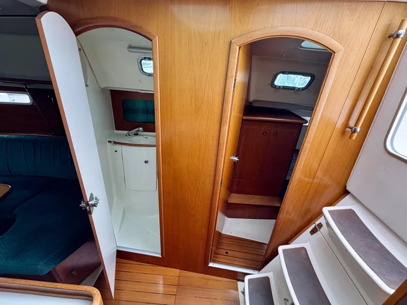 Slide: The Image of Interior of 2001 Beneteau Oceanis 331 sailboat, featuring wood paneling and compact design. - 27