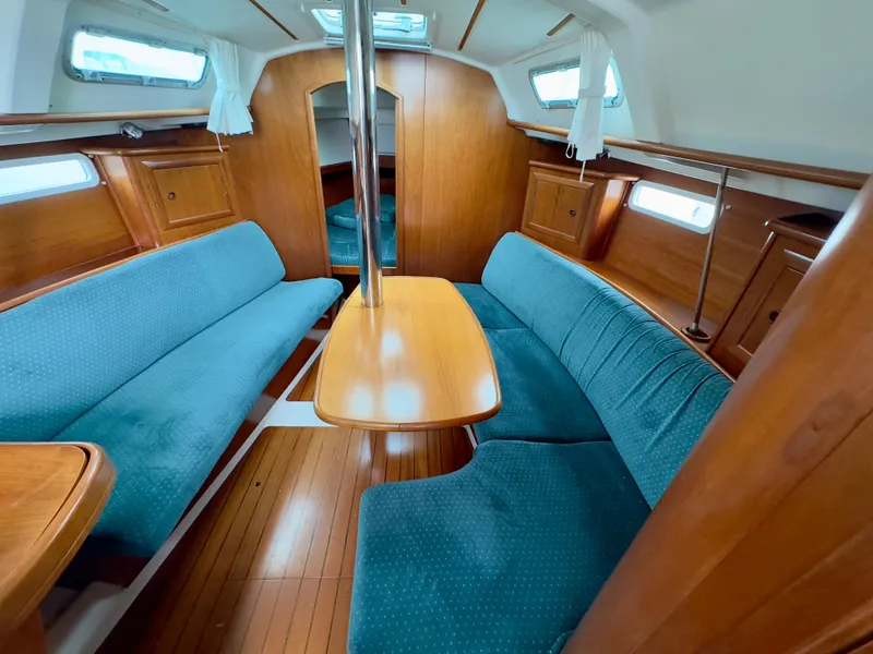 Slide: The Image of Interior of 2001 Beneteau Oceanis 331 sailboat with blue seating and wooden finishes. - 8