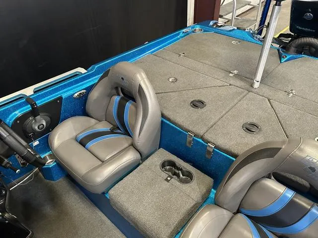 Slide: The Image of 2018 Bass Cat Boats Lynx interior with gray and blue seating, spacious deck, and storage compartments. - 15
