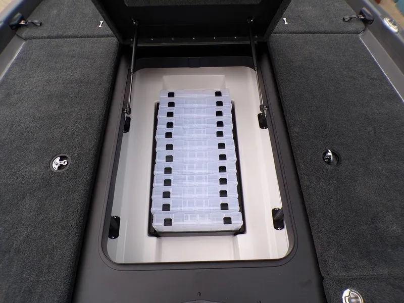 Slide: The Image of 2025 Skeeter ZXR21 boat storage compartment with organized tackle boxes. - 10