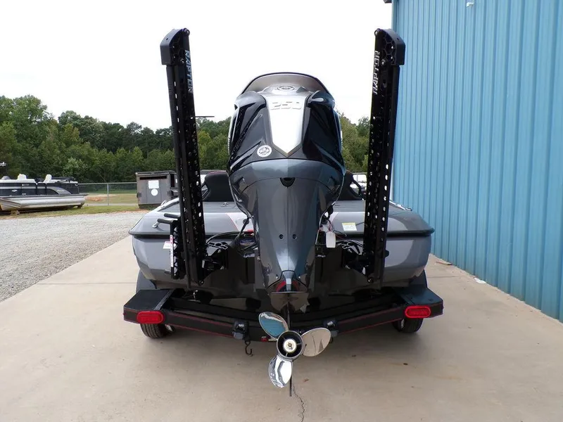 Slide: The Image of 2025 Skeeter ZXR21 boat, rear view, parked on concrete near blue building. - 14