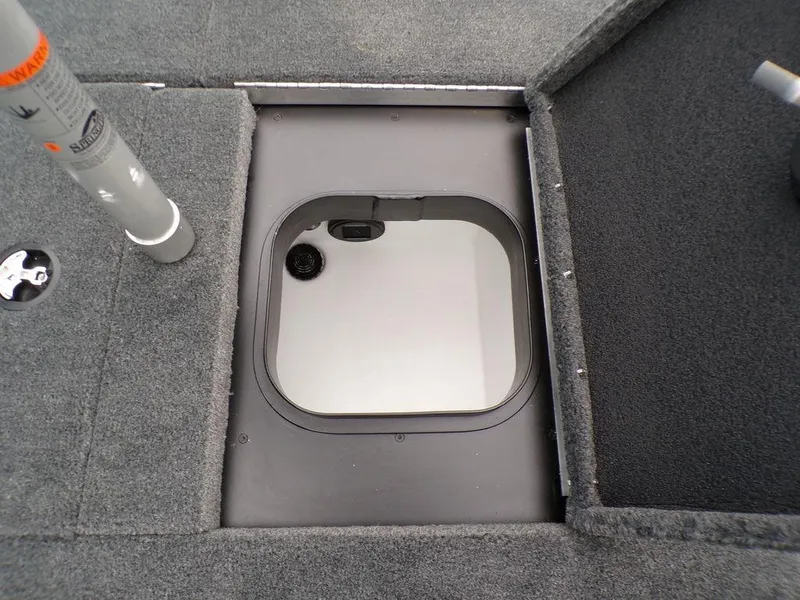 Slide: The Image of 2025 Skeeter ZXR21 boat storage compartment with gray carpeted interior. - 16