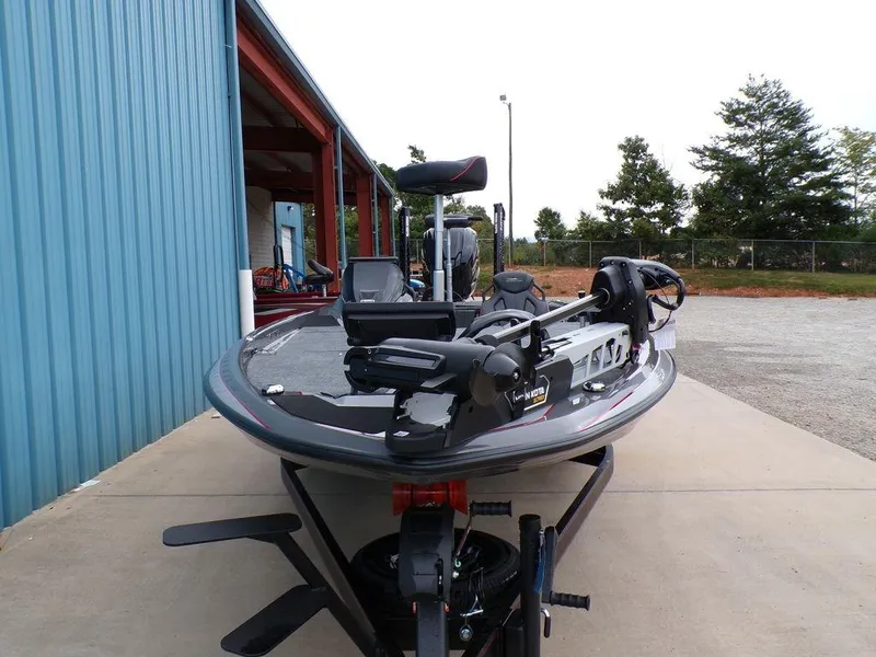 Slide: The Image of 2025 Skeeter ZXR21 boat parked outside a blue building. - 4