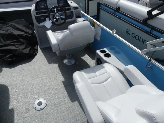 Slide: The Image of 2025 Sweetwater SW2286QS boat interior with white seating and steering console. - 8