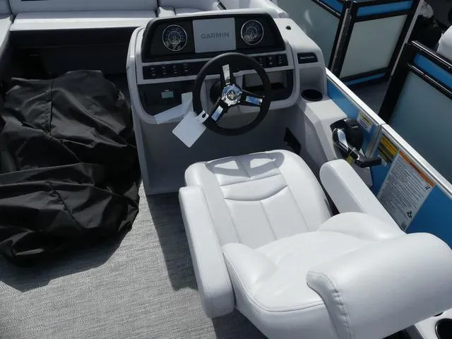 Slide: The Image of Sweetwater SW2286QS 2025 boat interior with Garmin dashboard and white captain's chair. - 9