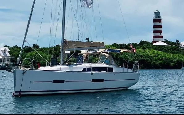The Image of Sailing yacht Dufour 382 Grand Large 2016 near a striped lighthouse. - 0