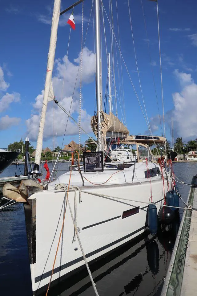 Slide: The Image of 2016 Dufour 382 Grand Large sailboat docked in a sunny marina. - 2