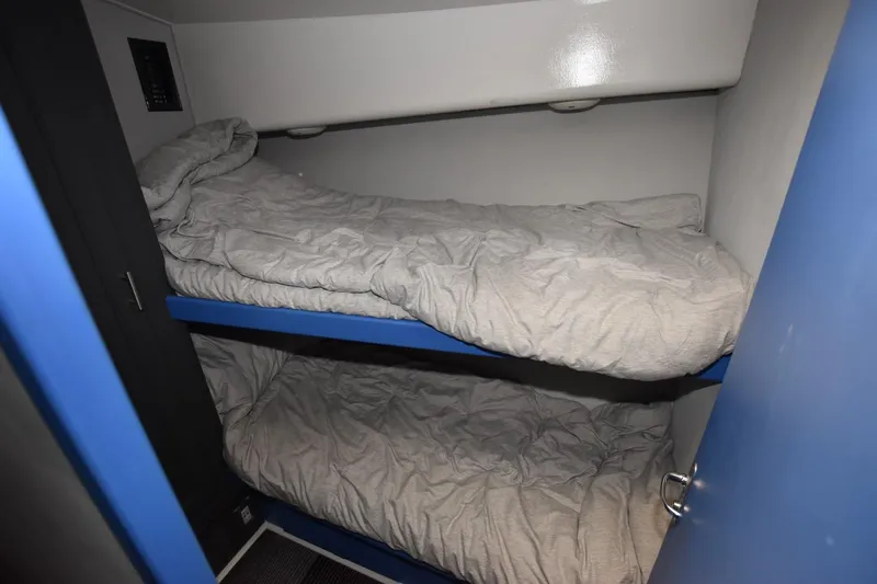 Slide: The Image of Bunk beds in 1997 Viking 50 Convertible yacht cabin, featuring blue accents and cozy bedding. - 18