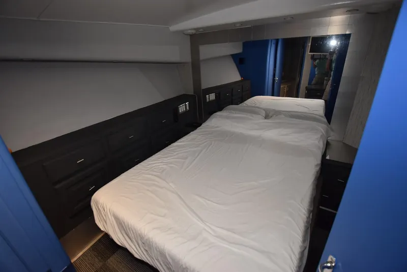 Slide: The Image of 1997 Viking 50 Convertible yacht bedroom with white bedding and dark cabinetry. - 19