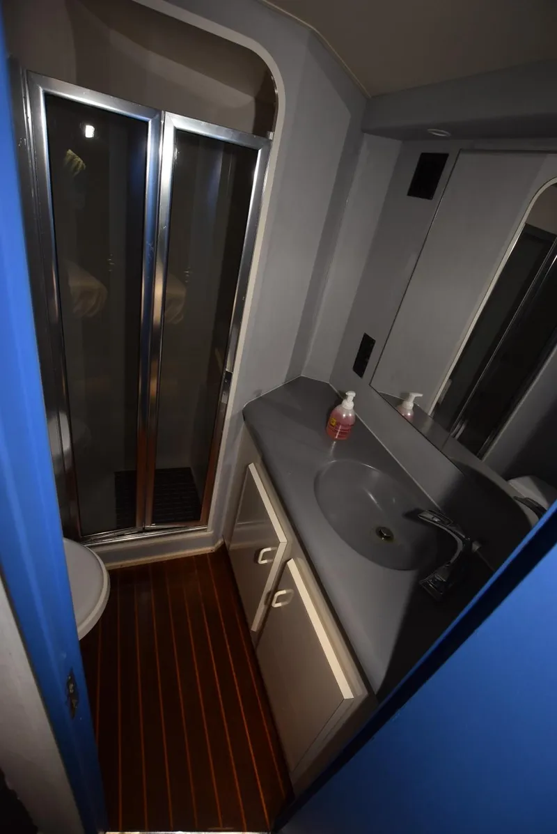 Slide: The Image of 1997 Viking 50 Convertible yacht bathroom with shower, sink, and wooden flooring. - 21