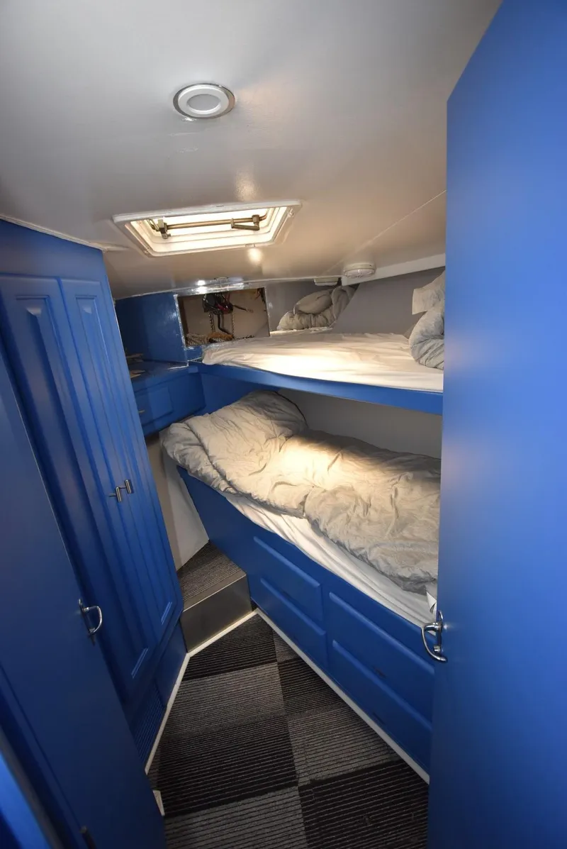 Slide: The Image of 1997 Viking 50 Convertible cabin with blue bunk beds and modern lighting. - 22